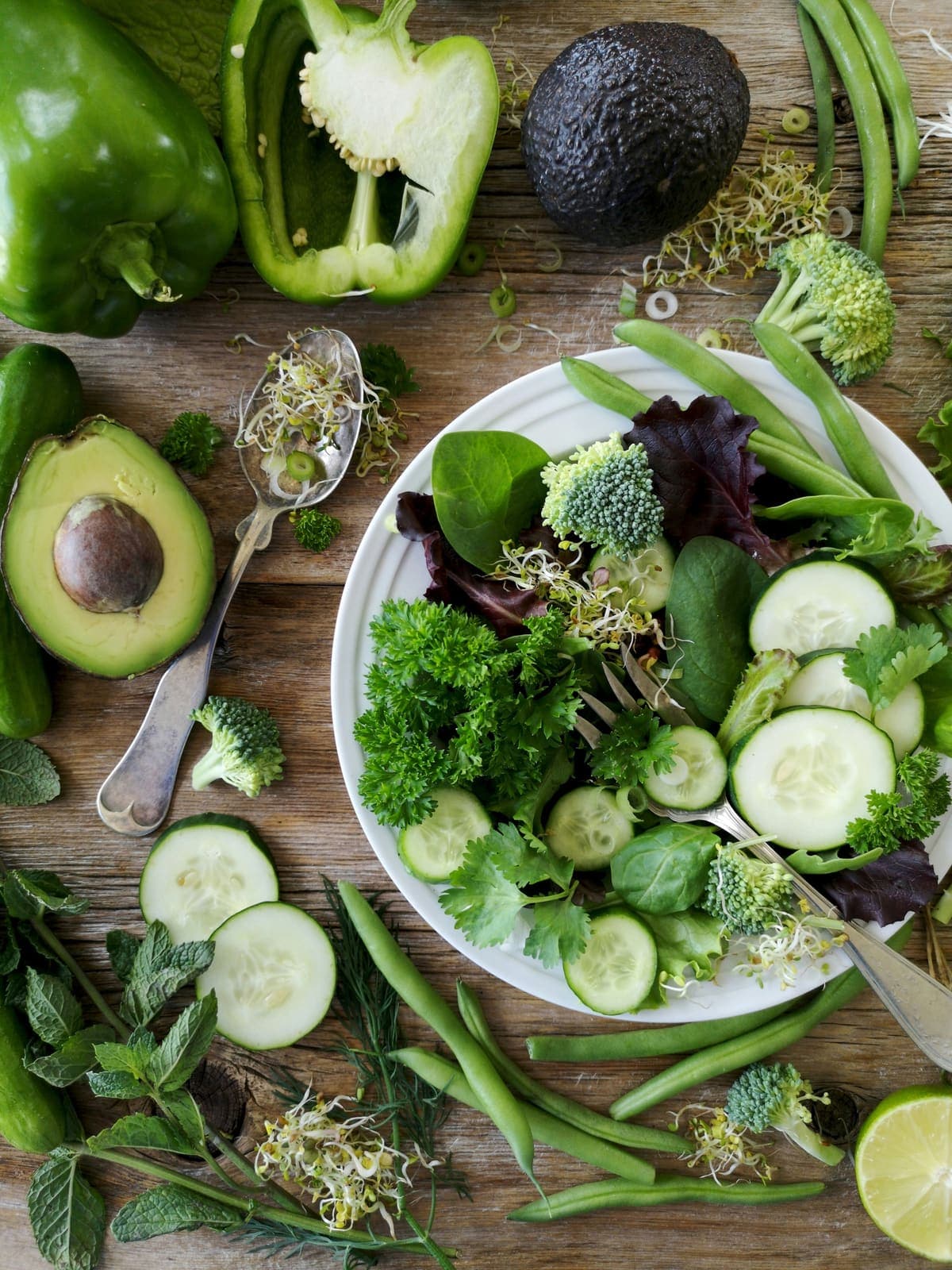 Frischer grüner Salat mit Gemüse auf einem Holztisch